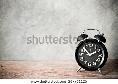 alarm clock on wood table in vintage color style