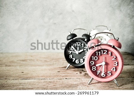 alarm clock on wood table in vintage color style