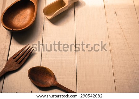 Wooden scoop and spoons on white wooden table, kitchen tool background