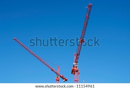 Two cranes working high above city