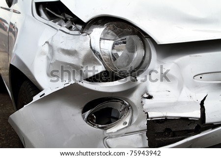 Damage to the front of a white car after an accident.