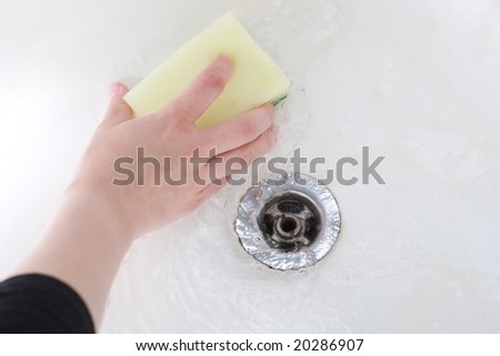 Sponge in hand washing the bath