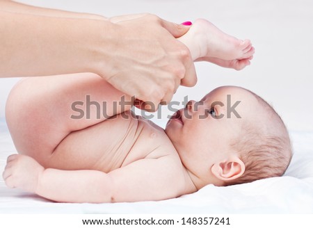 Baby massage Mother massaging baby's legs Isolated on white background Baby massage Mother massaging baby's legs Isolated on white background