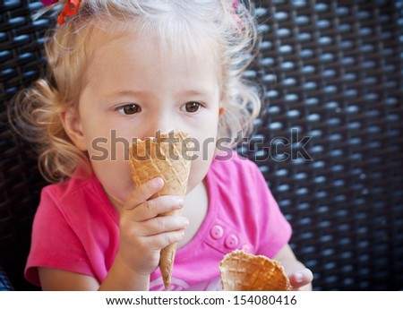 toddler girl with ice cream sitting in cafe