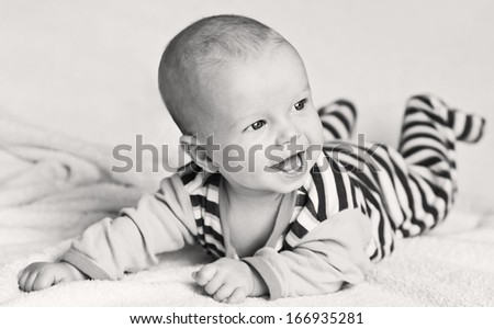 happy laughing baby boy lying on his stomach  (black and white)