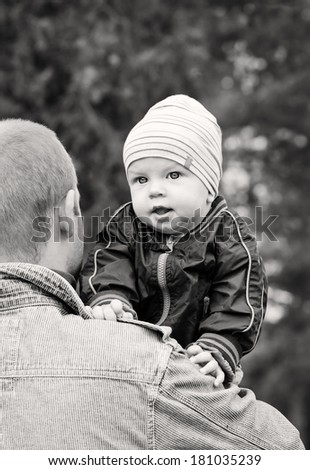 baby on the shoulder of his father walking ( black and white )