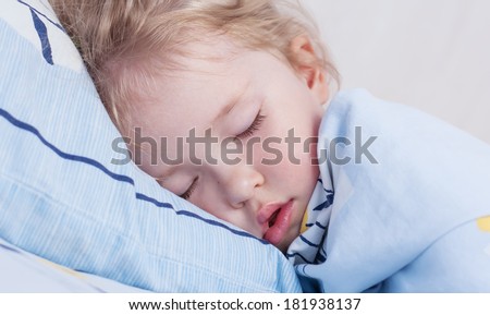 toddler girl is sleeping covered with a blanket