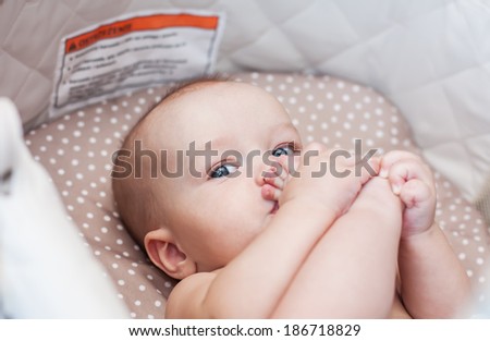 cute baby boy with feet in mouth