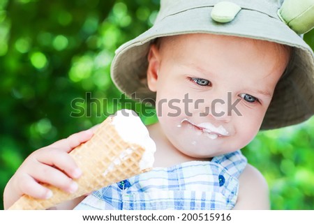 happy toddler boy eating ice cream on a summer day