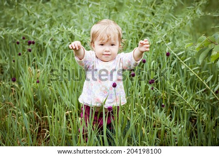 Cute Toddler Girl in the grass raise your hands up