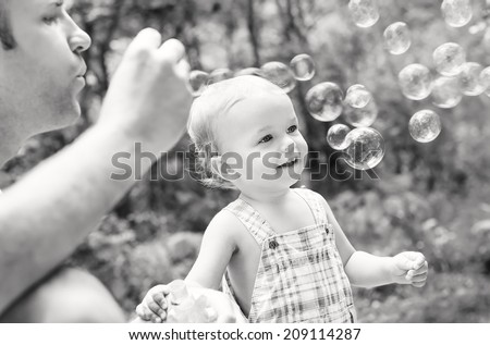 father playing with his son outdoors ( black and white )