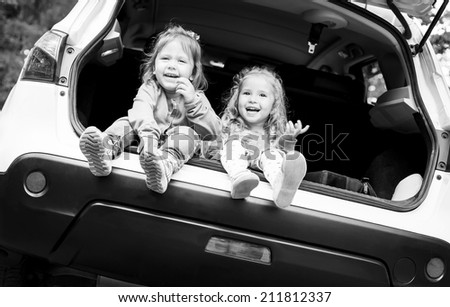 two happy kids in the car  ( black and white )