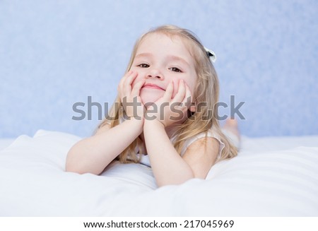 Adorable smiling little girl waked up in her bed