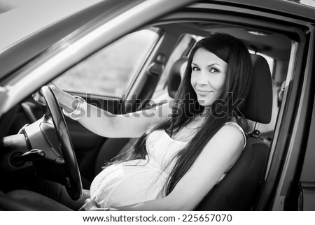 pregnant woman in driving seat of the car  ( black and white )
