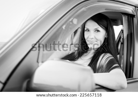 Beautiful happy woman driving her car  ( black and white )