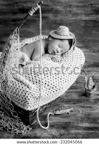 cute newborn baby boy sleeping in a hat fisherman  ( black and white )