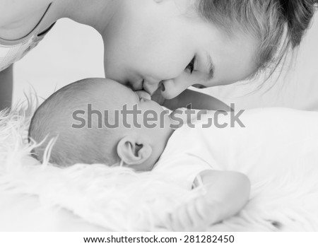 Cute little sister kisses newborn brother ( black and white )