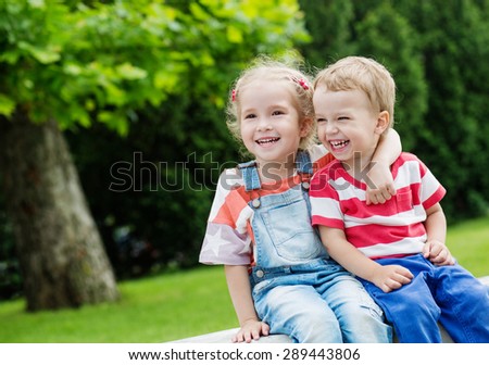 Happy Toddler brother and sister hugging in summer