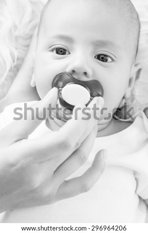 Cute newborn baby with a pacifier ( black and white )
