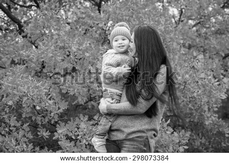 Happy mom and toddler boy on walk  in autumn ( black and white )