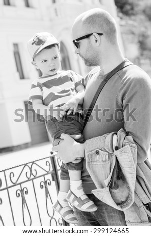 Father holding his son toddler walking outdoors ( black and white )