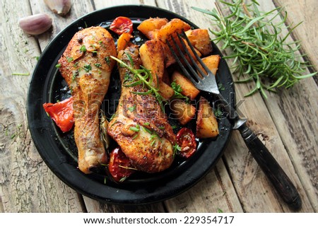 Roasted chicken legs with fried potatoes and fresh herbs