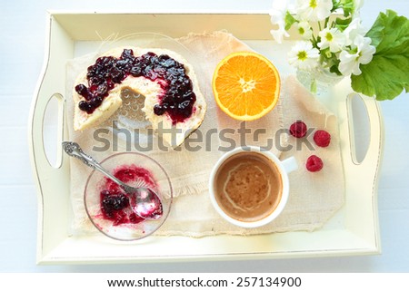 Tray with breakfast. Roll with currant jam and cup of coffee