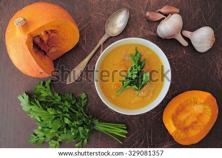 Pumpkin soup with fresh parsley, garlic and pork meat. Above view on table