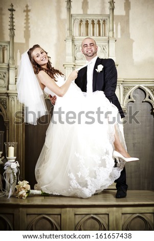 Young couple on their wedding day posing in chapel