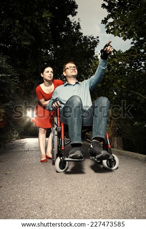 Disable man on wheel chair with nice female guide