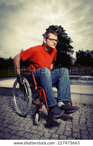 Young man on wheel chair - riding in park