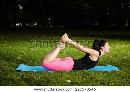 Freshly pregnant nice woman exercising yoga outdoor