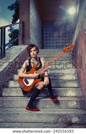 Woman player posing on street city location for stylish musician portraits