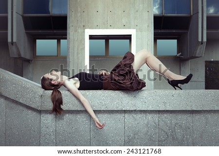 Pretty brunette lady laying on concrete block