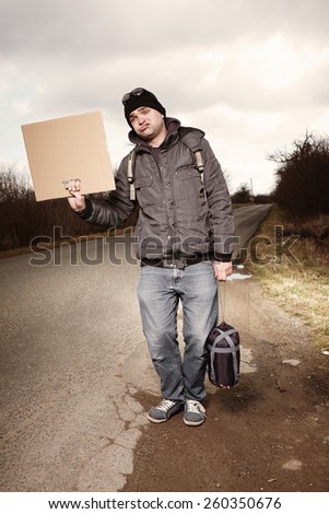 Ugly man hitch-hiking with blank cardboard