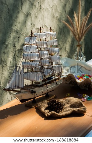 wooden sail ship toy model with shells on the table