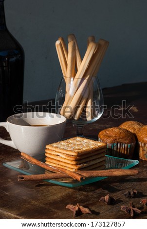 Breadsticks ,Banana cake and Biscuits with black coffee in the morning on wooden table