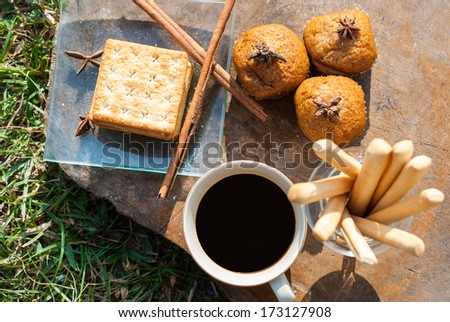 Breadsticks ,Banana cake and Biscuits with black coffee in the morning on wooden table