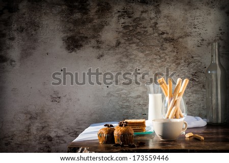 Breadsticks ,Banana cake , milk  and Biscuits with black coffee in the morning on wooden table
