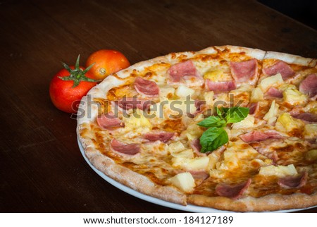Hawaiian Pizza , pineapple , ham and cheese on wooden table
