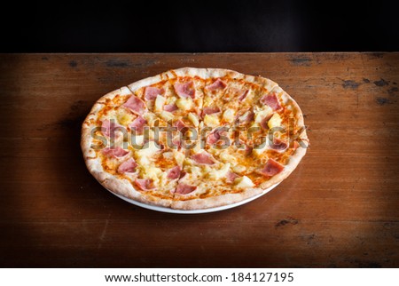 Hawaiian Pizza , pineapple , ham and cheese on wooden table