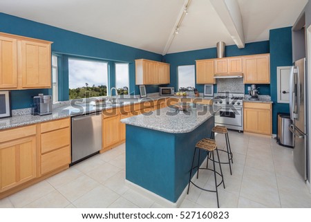 Kitchen in Blue with Island, bar chairs and Granite Countertop