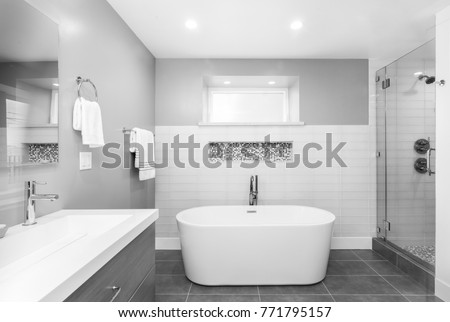 Luxury bathroom interior with an oval bathtub black stone tiles and with glass shower in black and white