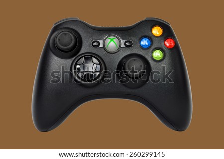 SAO PAULO, BRAZIL - MAR 13, 2014: The wireless gamepad for the Xbox 360, a home video game console produced by Microsoft, isolated on brown background.