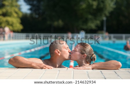 Portrait of a couple kissing by the swimming pool