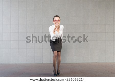 Full body portrait of young business woman pointing finger
