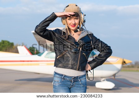 Portrait of young pilot against airplane
