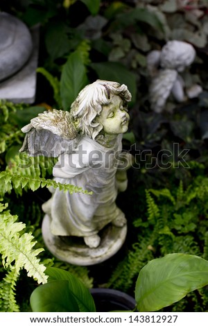 Cupid - garden decorative statue on green grass