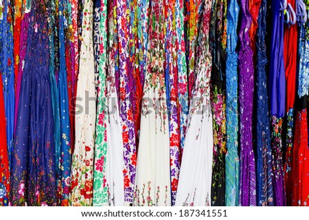 Rows of colourful silk scarfs hanging at a market stall in Thailand