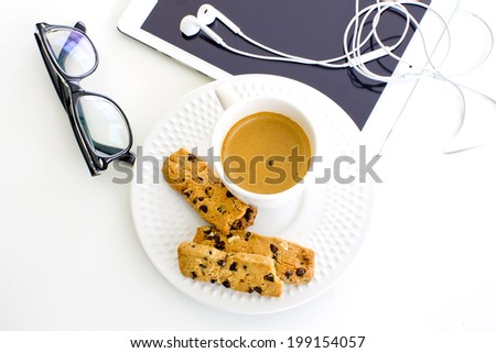 modern business background. Computer tablet with eyeglasses and white coffee and cookies on white background